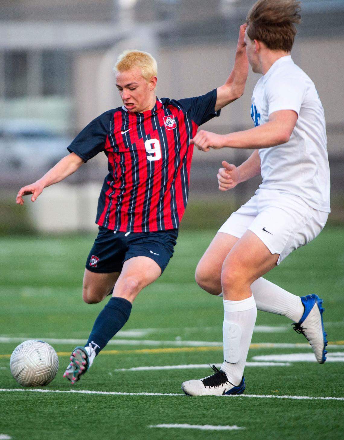 Silas forward Joseph Nichols (9) passes the ball as Stadium defender Landon Seaholm (26) defends during a 3A Pierce County League game at Silas High School in Tacoma, Wash. on April 11, 2023. Silas won 3-0.
