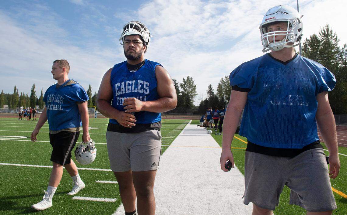 Graham-Kapowsin seniors Vega Ioane (center) and twins Curtis Hill (left) and Hunter Hill will anchor the Eagles line. They are shown during football practice at Graham-Kapowsin High School in Graham, Washington, on Wednesday, Aug. 18, 2021.
