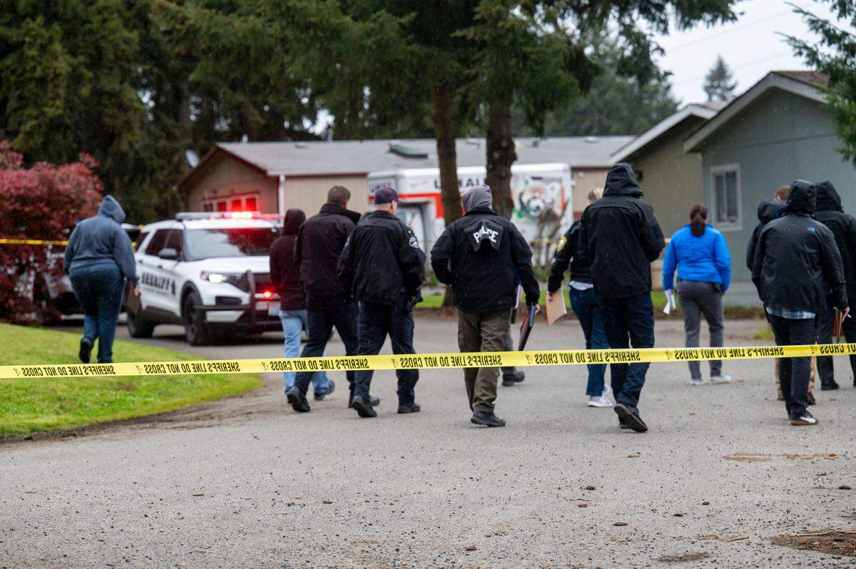 The Pierce County Force Investigation Team walks through the scene of a deputy-involved shooting near 161st Street East and 62nd Avenue near Frederickson on Thursday, May 12, 2022.