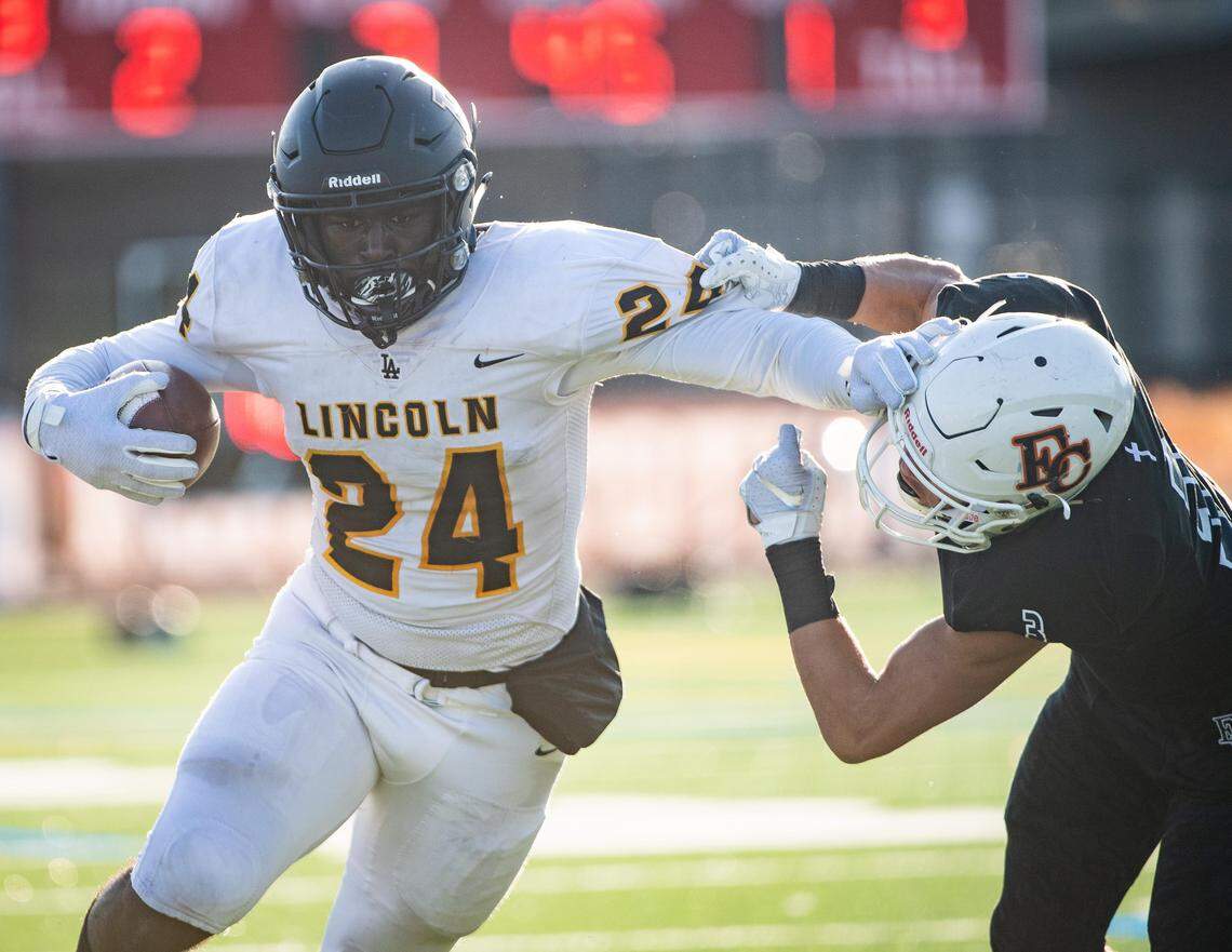 Lincoln’s Julien Simon stiff-arms Eastside Catholic’s Everette Isaac while running during the second quarter. Lincoln played Eastside Catholic in the 3A football semifinal game at Sammamish High School in Bellevue, Wash., on Saturday, Nov. 30, 2019.