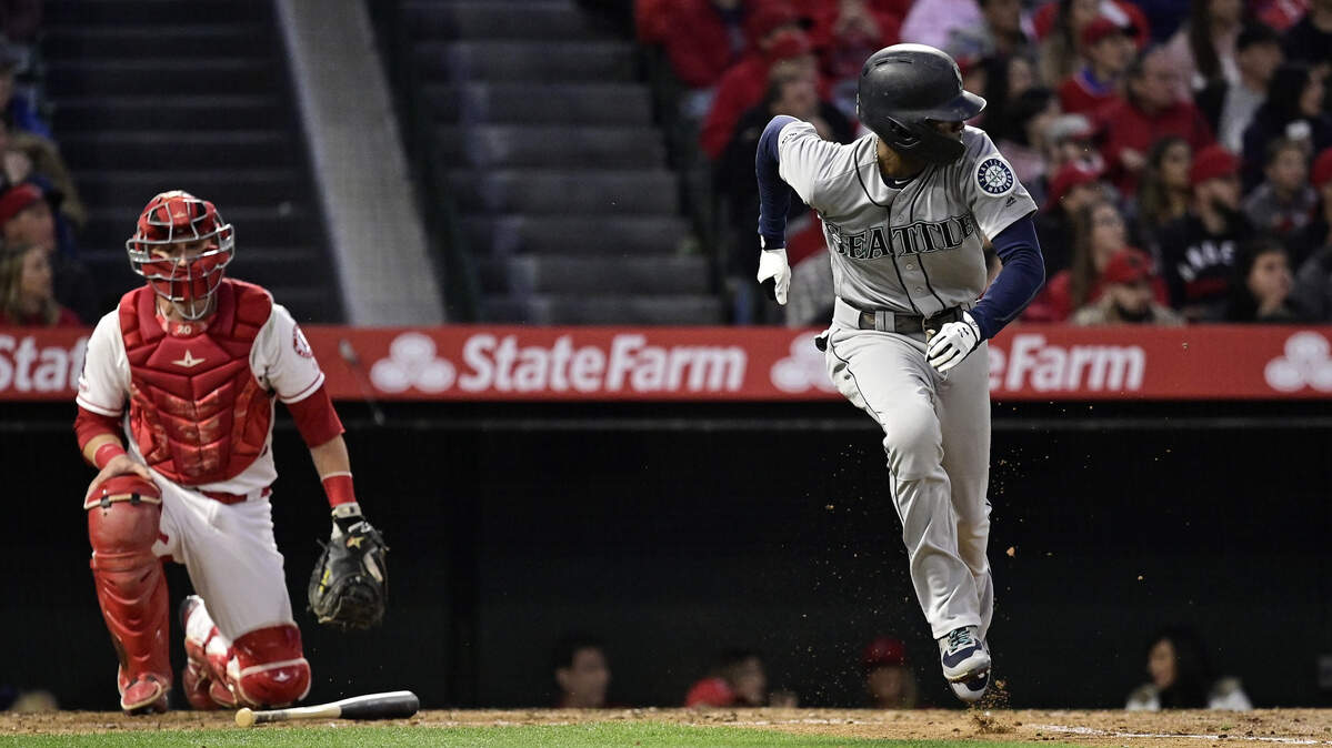 Seattle Mariners’ Dee Gordon, right, runs to first as he hits an RBI single while Los Angeles Angels catcher Jonathan Lucroy watches during the fourth inning of a baseball game Saturday, April 20, 2019, in Anaheim, Calif. (AP Photo/Mark J. Terrill)