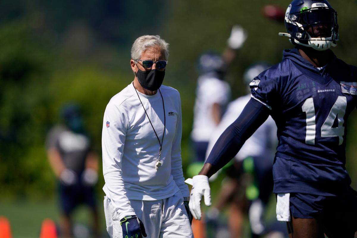 Seattle Seahawks head coach Pete Carroll looks on as wide receiver DK Metcalf warms up during NFL football training camp, Friday, Aug. 14, 2020, in Renton, Wash. (AP Photo/Ted S. Warren, Pool)