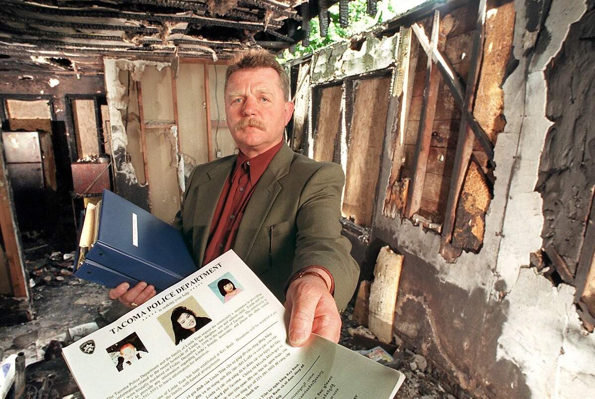 On June 10, 1999, Tacoma police homicide detective Robert Yerbury stands in the fire-gutted home of Linda Tran, about six months prior with her 9-year-old daughter Patricia and 22-month-old son Austin. Yerbury is holding a informational flyer that the police published in English and various Asian languages and distributed at the time asking for the public’s help in solving the homicide.