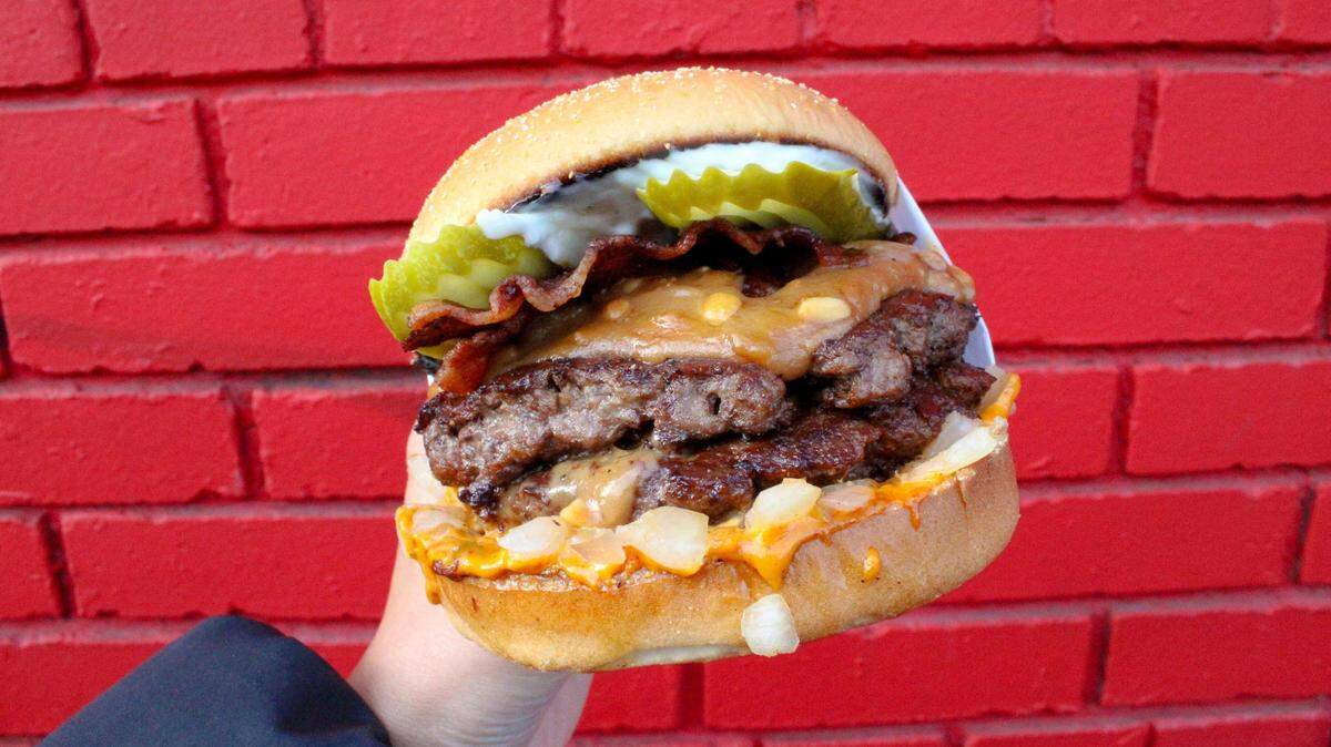 The Portland-based chain Killer Burger serves a curated menu of fresh-beef burgers, including the popular Peanut Butter Pickle Bacon Burger, pictured here as a double-patty. The company still hopes to open a franchise in Tacoma among other sites.