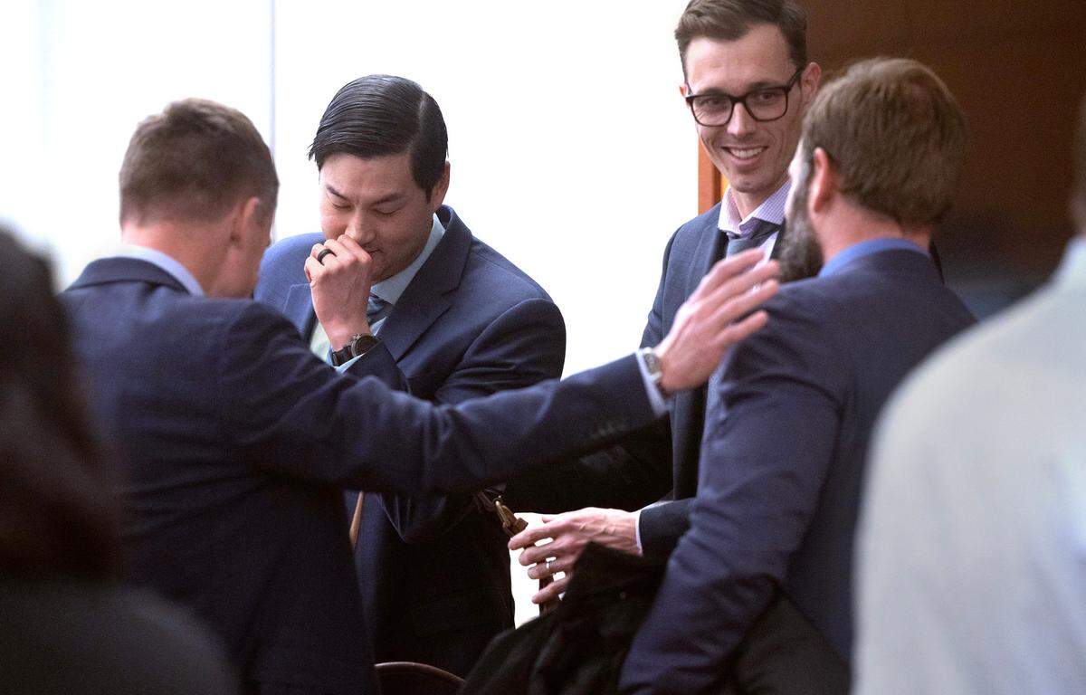 Tacoma police officers Timothy Rankine (left) and Matthew Collins (far right) confer with attorneys in Pierce County Superior Court in Tacoma, Wash., on Wednesday, Dec. 20, 2023. (Tony Overman / Pool Photo - The News Tribune)