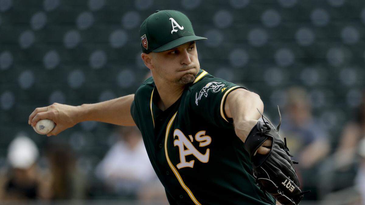Oakland Athletics starting pitcher Kendall Graveman throws against the Los Angeles Angels during the first inning of a spring baseball game on March 8, 2018 in Mesa, Ariz.
