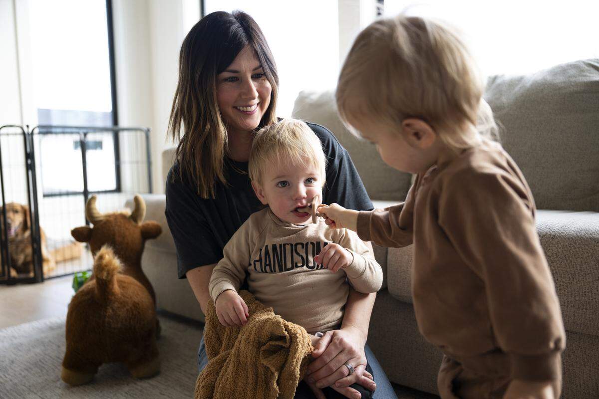 Kailee Pederson holds her son Crew while twin Lake puts a pacifier in his brother’s mouth at home, on Friday, Jan. 9, 2026 in Buckley, Wash. The twin boys were born after severe complications during pregnancy in May 2024. Lake recently underwent surgery for his lungs. 