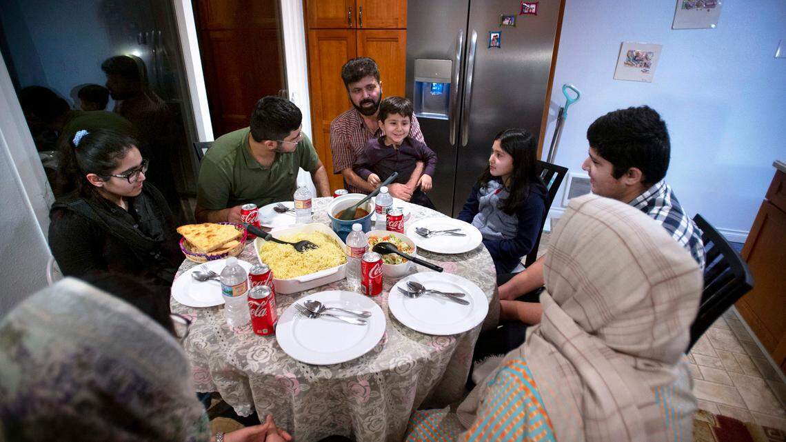 All eight members of the Stanakzai family gather around the dinner table at their home in Puyallup, Washington, on Saturday, Feb. 5, 2022. Najibullah Stanakzai, who worked as a constuction engineer in Kabul, Afghanistan, and his wife Nabila Stanakzai, a professional seamstress who had previously been denied her studies to become an attorney by the Taliban - shuttled between refugee camps with their six children before finding a home in Puyallup two months ago.