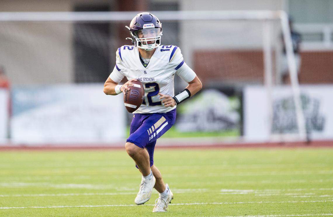 Lake Stevens’ Kolton Matson (12) scrambles to looking for an open receiver during the first half of the game against Sumner at Sumner High School, on Friday, Sept. 6, 2024, in Sumner, Wash.