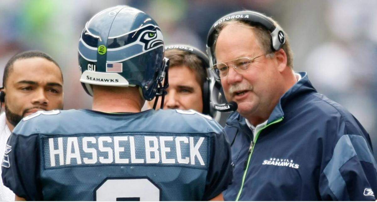 Seahawks coach Mike Holmgren, right, talks with quarterback Matt Hasselbeck (8) and backup quarterback Seneca Wallace, back left, during a time out against the St. Louis Rams in game Sept. 21, 2008 in Seattle. The Seahawks announced Wednesday Hasselbeck and Holmgren will be the 13th and 14th members of their Ring of Honor, to be inducted in October 2021.