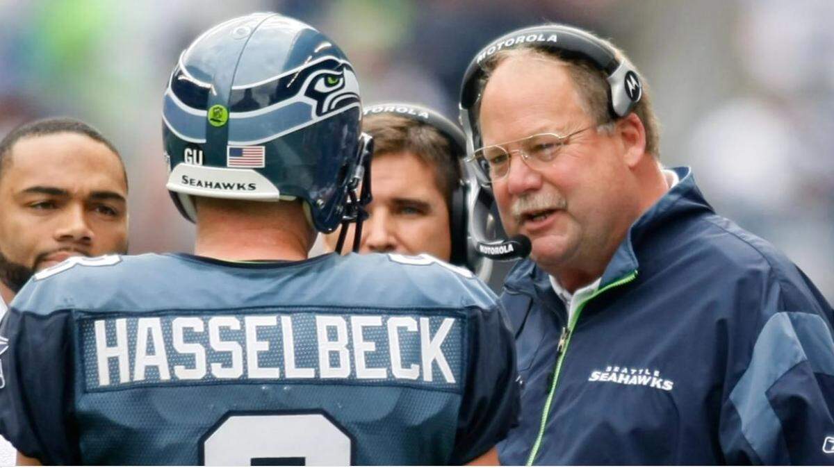 Seahawks coach Mike Holmgren, right, talks with quarterback Matt Hasselbeck (8) and backup quarterback Seneca Wallace, back left, during a time out against the St. Louis Rams in game Sept. 21, 2008 in Seattle. The Seahawks announced Wednesday Hasselbeck and Holmgren will be the 13th and 14th members of their Ring of Honor, to be inducted in October 2021.