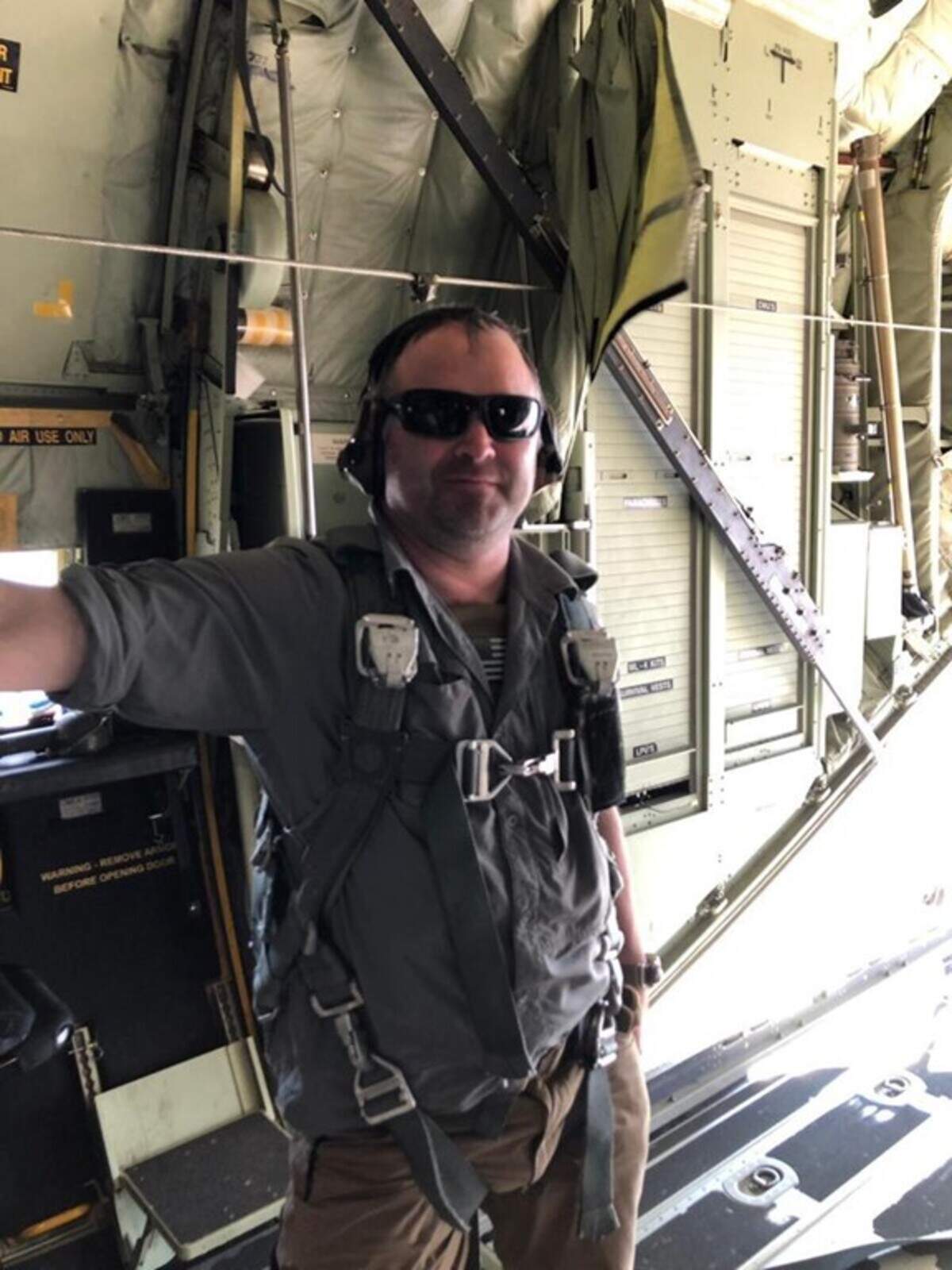 Clifton Funkhouser stands in a C-130 aircraft with Air Force pararescue specialists in 2019 in Baghdad.
