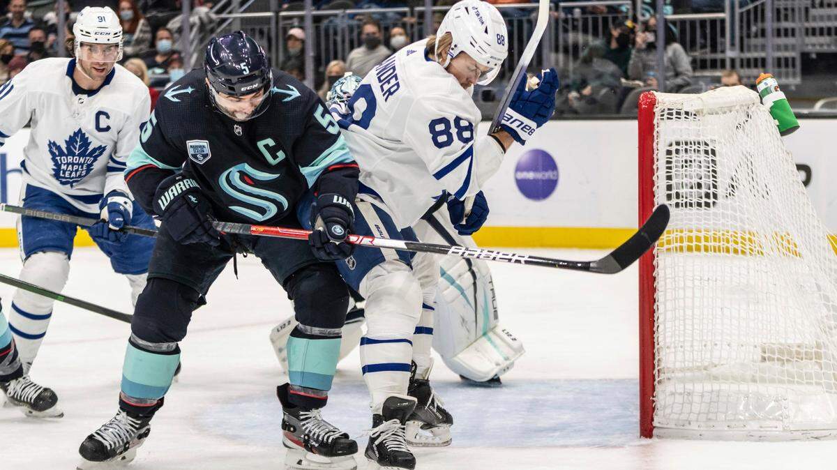 Toronto Maple Leafs right wing William Nylander (88) and Seattle Kraken Seattle Kraken defenseman Mark Giordano (5) battle for the puck during the first period of an NHL hockey game, Monday, Feb. 14, 2022, in Seattle. (AP Photo/Stephen Brashear)