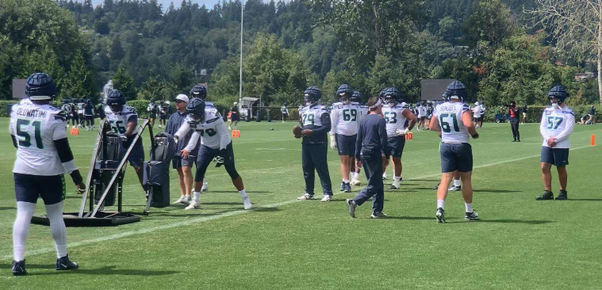 New starting center Connor Williams (57, far right) stands and watches fellow Seahawks offensive linemen go through drills in Williams’ first day as Seattle Seahawks, Aug. 12, 2024. The seventh-year NFL veteran was hoping to begin practice within a week following his torn knee ligament in Dec. 2023.