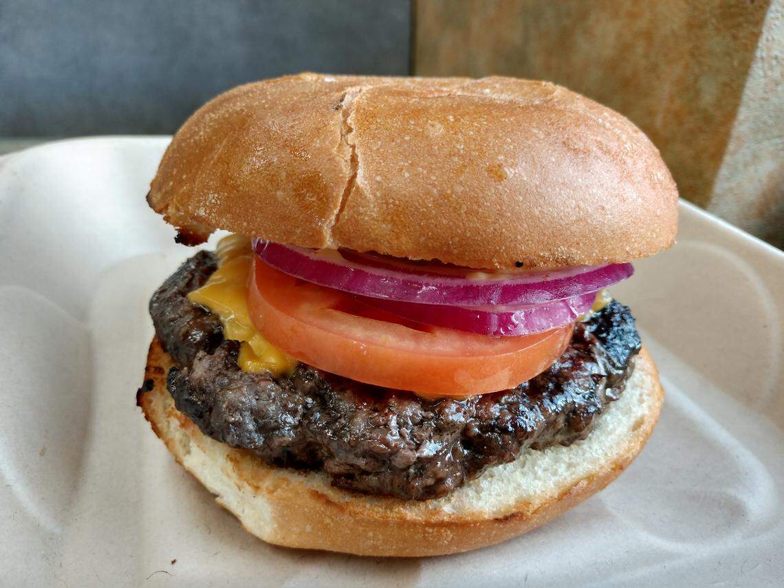 A burger with tomato and red onion from Build-A-Burger in Tacoma.