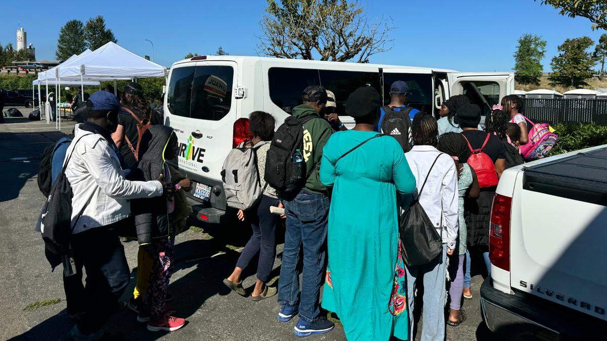 Asylum-seeking families being transported from King County encampment.