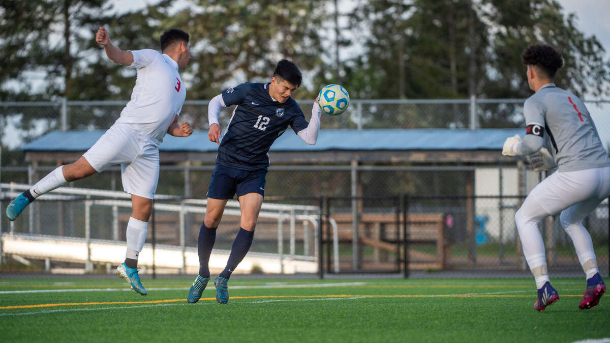 Bellarmine Prep’s Peter Radovich heads in the go-ahead goal as Eastmont’s Mark Gomez defends while goal keeper Armando Mendoza looks on during the second half of a 4A State tournament first-round game on Wednesday, May 18, 2022, at Bellarmine Prep High School in Tacoma, Wash.