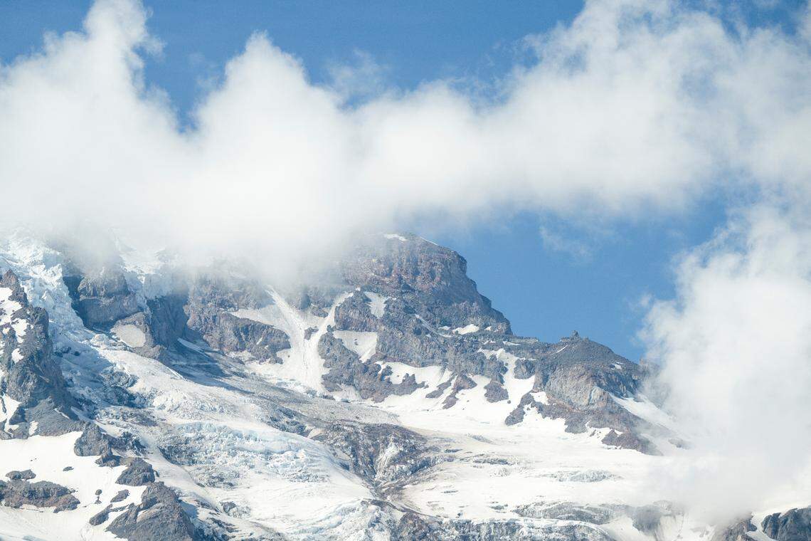 Clouds gather near the top of Mount Rainier, where ice and snow fragments are visible, left, on Friday, June 6, 2025, at Mount Rainier National Park.