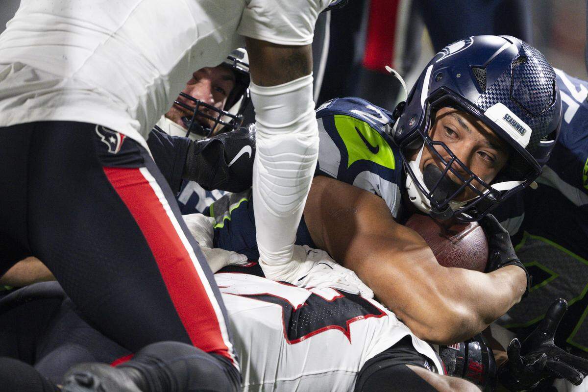 Seattle Seahawks running back Zach Charbonnet (26) lays at the bottom of the pile after scoring a touchdown against the Houston Texans during the first quarter of the game at Lumen Field, on Monday, Oct. 20, 2025, in Seattle.