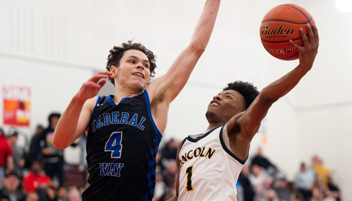 Lincoln’s O’Shea Lamar (1) is fouled while going up for the net against Federal Way’s Brayden McVey (4) during the second half of the 3A District 3/4 tournament boys semifinal on Tuesday, Feb. 18, 2025, in Tacoma, Wash.