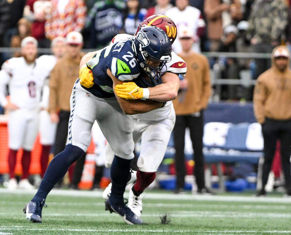 Seattle Seahawks running back Zach Charbonnet (26) is tackled by Washington Commanders safety Kamren Curl (31) during the first quarter of the game at Lumen Field, on Sunday, Nov. 12, 2023, in Seattle, Wash.