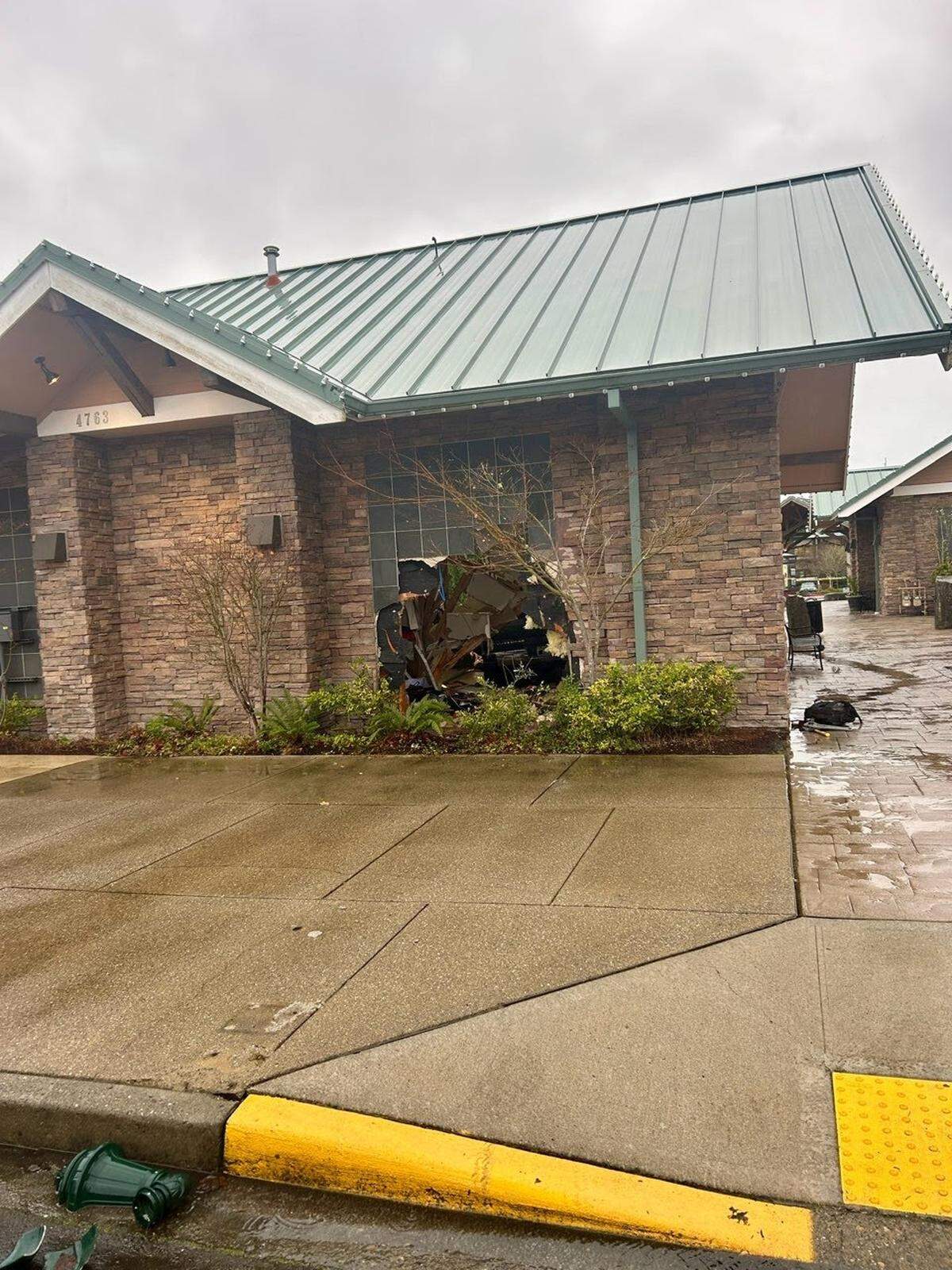 A hole shows where a vehicle rammed into a building in the 4700 block of Point Fosdick Drive Tuesday, Jan. 6, 2026, in Gig Harbor, Wash.
