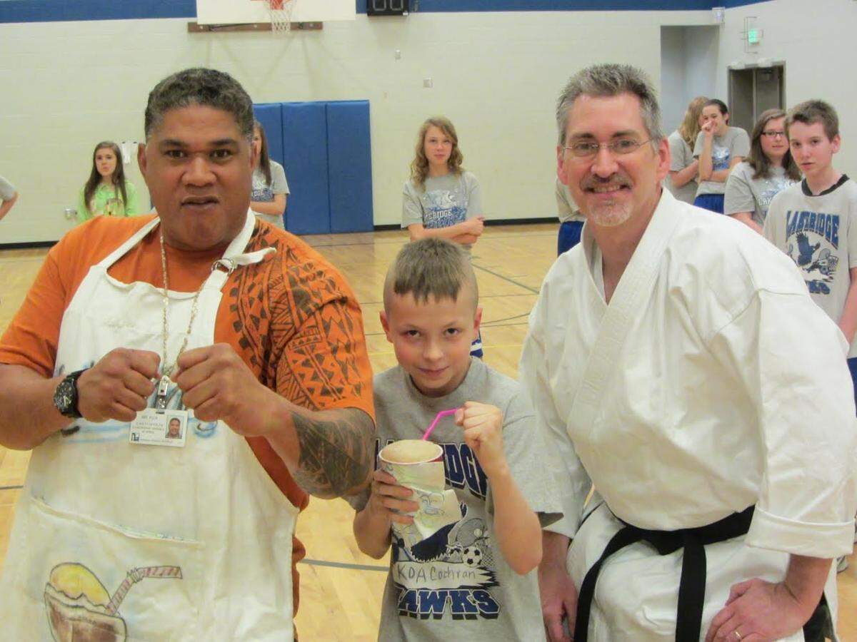Paul Fu’a, left, posing with Koa Cohran, middle, who earned the student of the week award from teacher Mike Osborn, right, in April 2013.