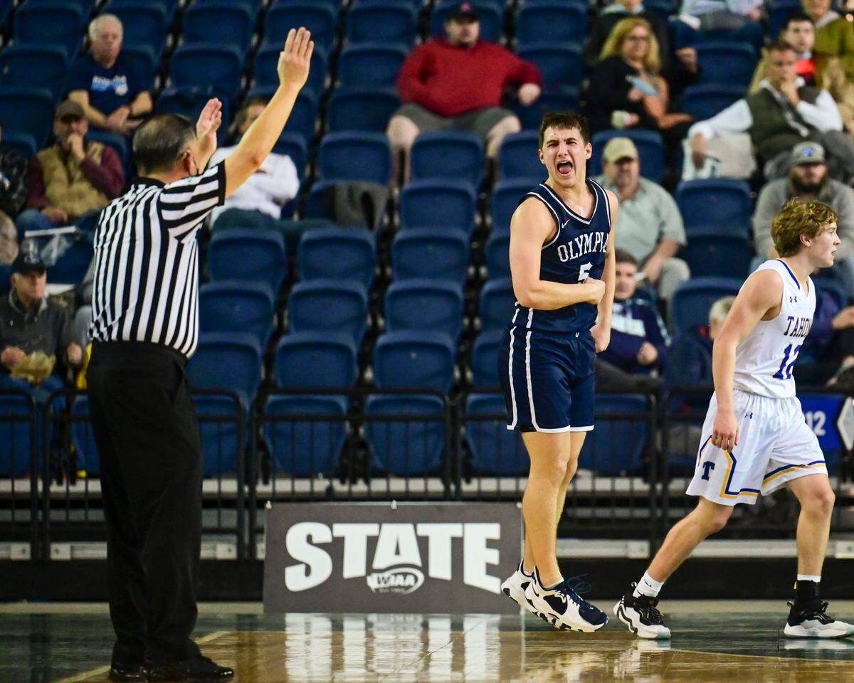 Olympia guard Mason Juergens (5) celebrates after scoring a 3-pointer as Tahoma guard Kody Kasper (12) walks over to collect the inbounds pass during the fourth quarter of a Class 4A quarterfinal state tournament game on Thursday, March 3, 2022, at the Tacoma Dome, in Tacoma, Wash.