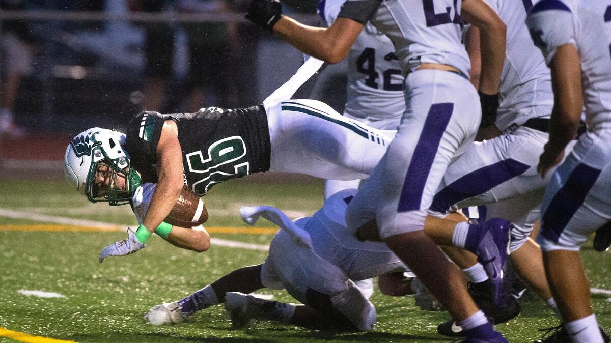 Peninsula running back Shawn Leonard dives for extra yards during Thursday night’s 3A SSC league opener football game against North Thurston at Roy Anderson Field in Gig Harbor on Sept. 19, 2019.