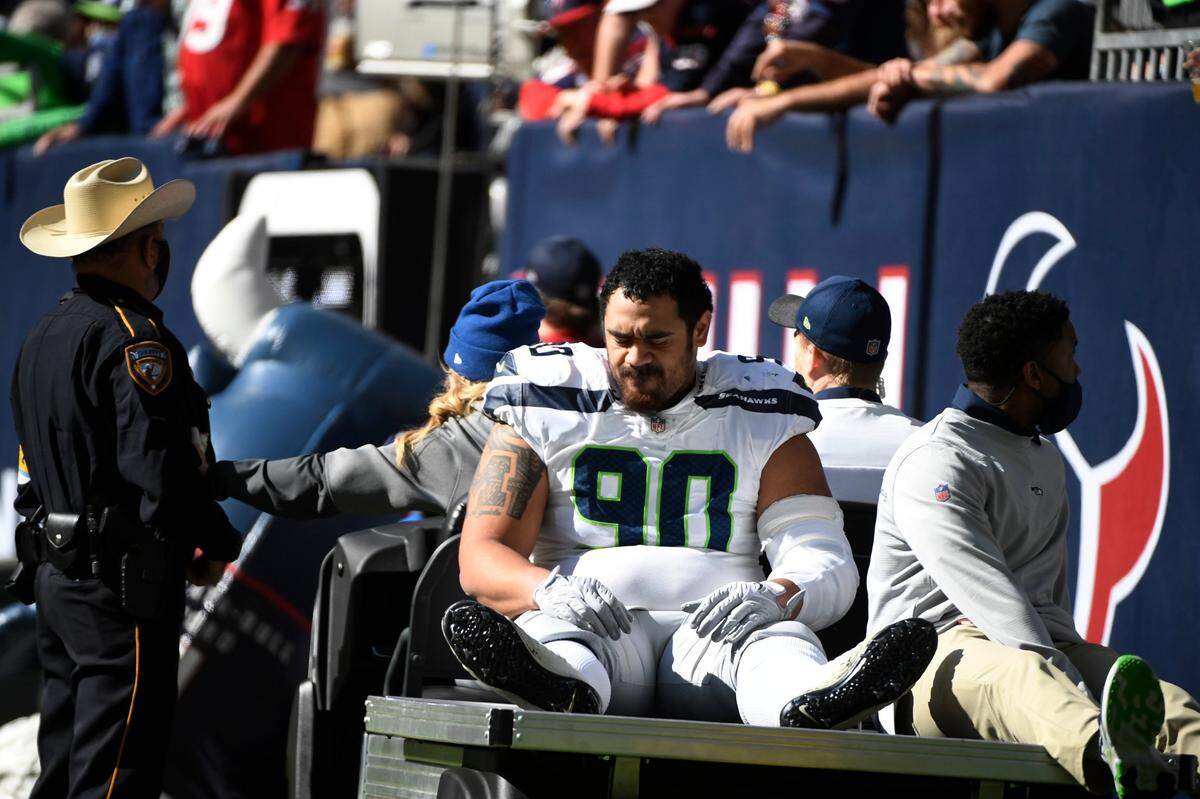 Seattle Seahawks defensive tackle Bryan Mone (90) is taken off the field after an injuryduring the first half of an NFL football game against the Houston Texans, Sunday, Dec. 12, 2021, in Houston. (AP Photo/Justin Rex )