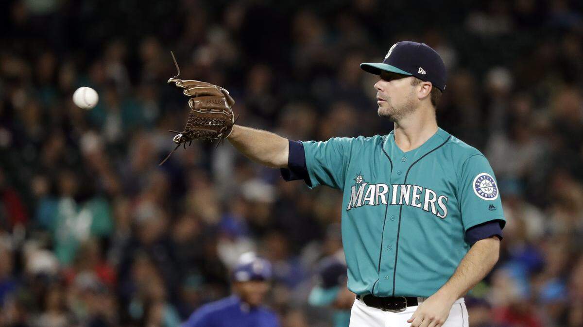 Seattle Mariners starting pitcher Wade LeBlanc reaches for the ball against the Texas Rangers in a baseball game Friday, Sept. 28, 2018, in Seattle. (AP Photo/Elaine Thompson)