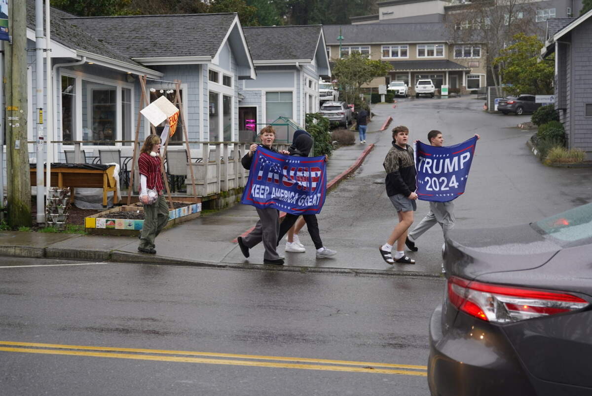 Counterprotesters hold up Trump flags during a walkout organized by Gig Harbor High School students, Friday, Feb. 13, 2026 in Gig Harbor, Wash.