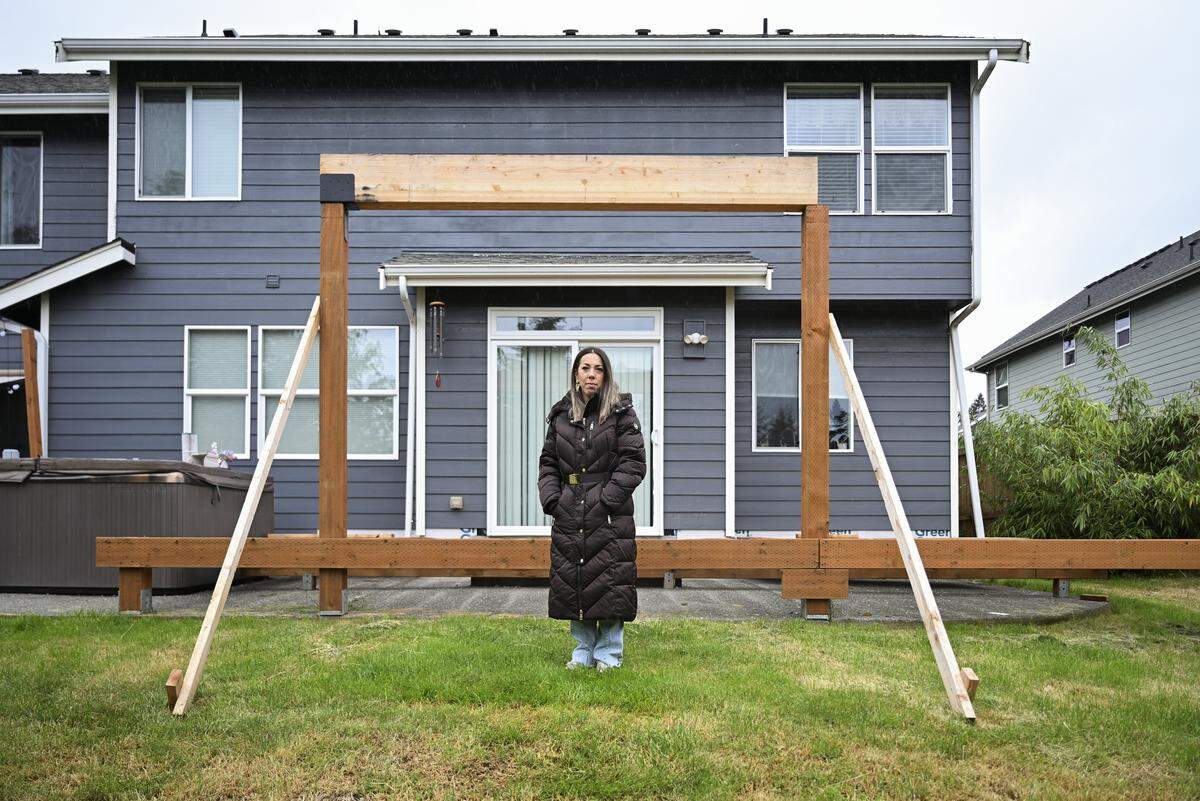 Brittany Gunderson poses for a portrait in front of the unfinished deck at her home on Friday, May 15, 2026, in Bonney Lake, Wash. Gunderson said the deck was being built for her disabled brother-in-law so he could spend time with family at home.