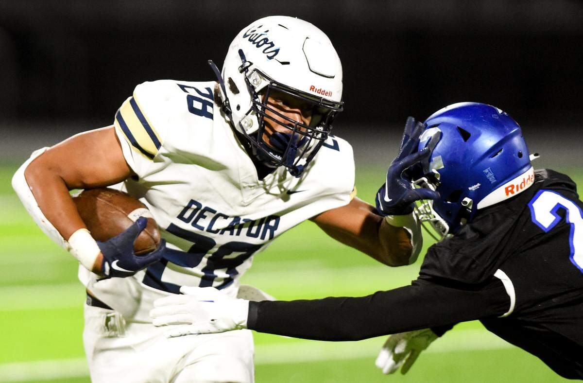 Decatur’s Nehemiah Washington (28) stiff arms Federal Way’s Zamaire Tellez (2) during the first half of the game at Federal Way Memorial Stadium, Thursday, Oct. 26, 2023, in Federal Way, Wash.