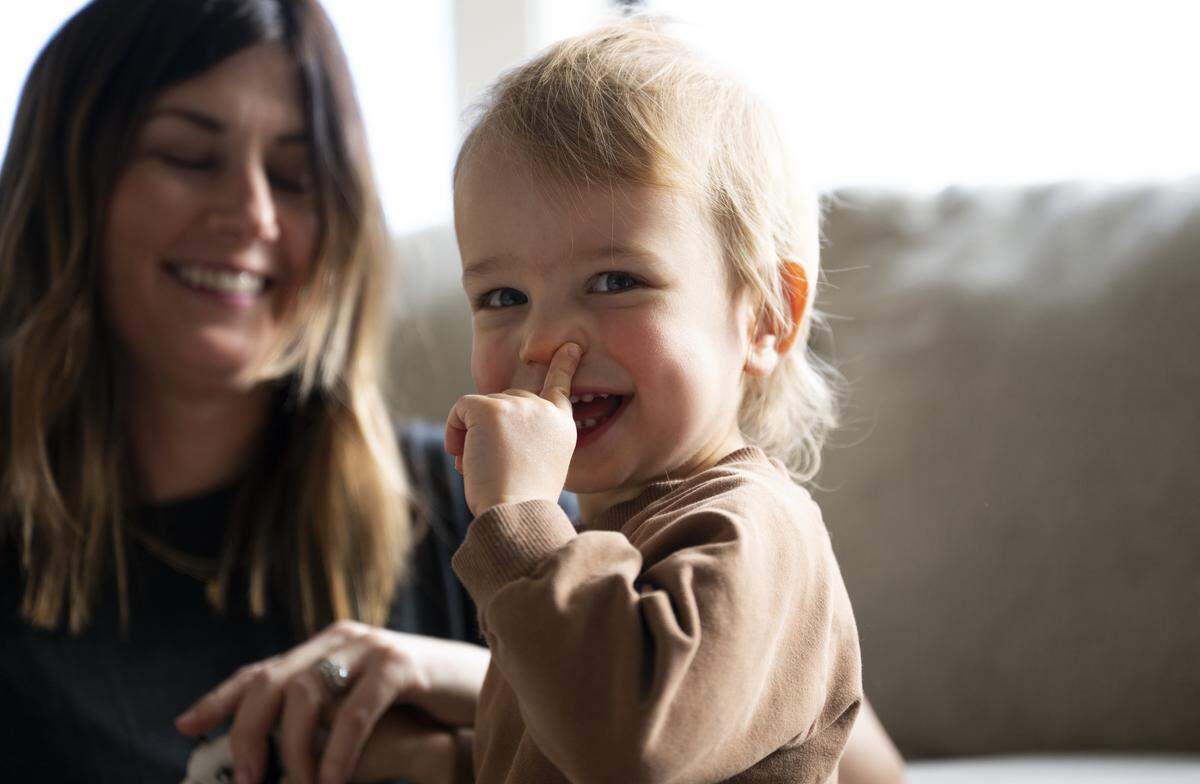 Lake Pederson, at almost 2 years old, smiles while playing with his mother Kailee and twin brother Crew at home, on Friday, Jan. 9, 2026 in Buckley, Wash. The twin boys were born after severe complications during pregnancy in May 2024. Lake recently underwent surgery for his lungs. 