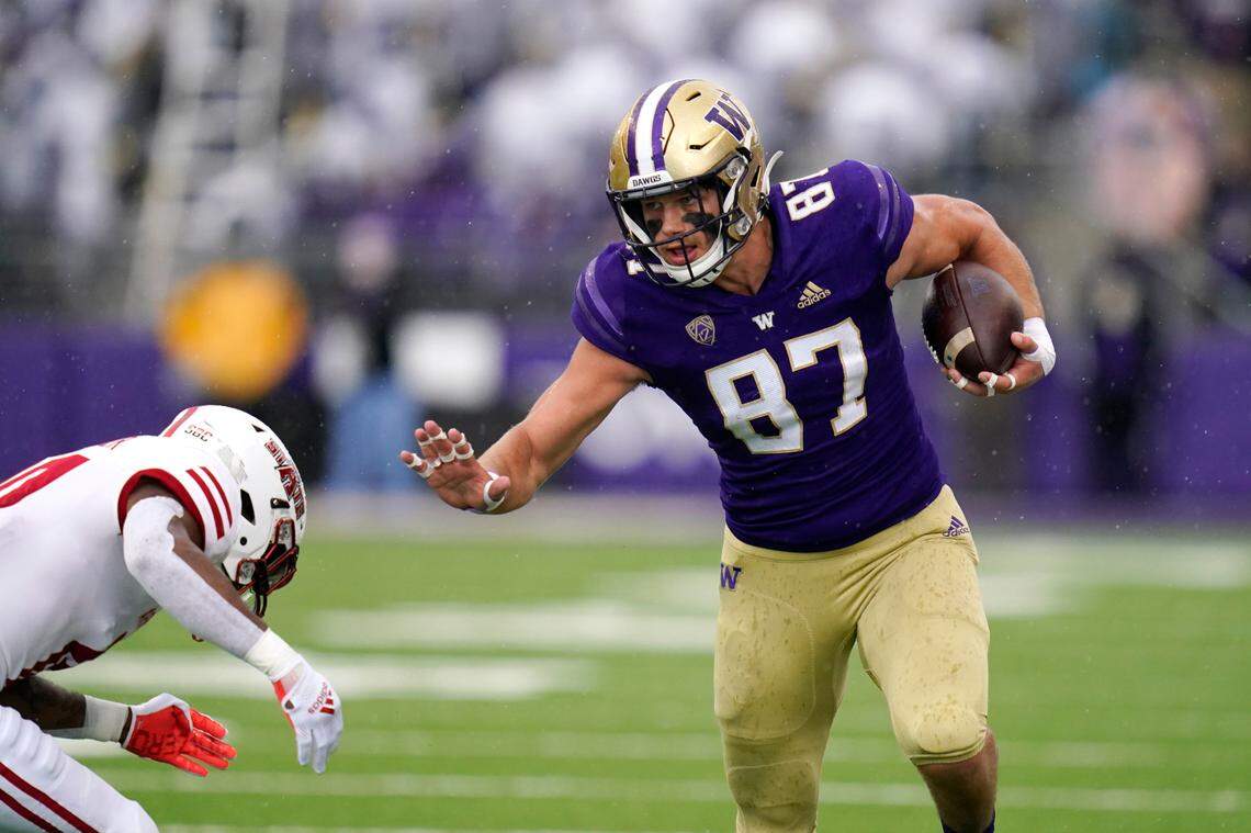 Washington’s Cade Otton (87) tries to avoid a tackle as he runs with the ball against Arkansas State in the first half of an NCAA college football game, Saturday, Sept. 18, 2021, in Seattle. (AP Photo/Elaine Thompson)