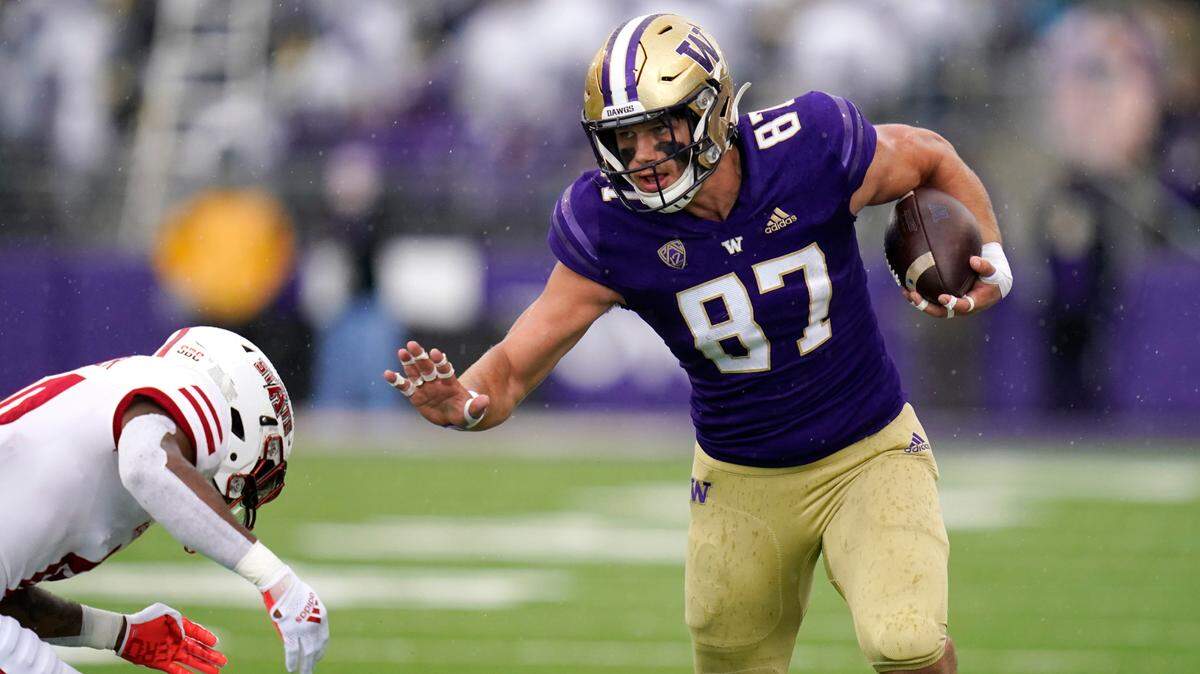 Washington’s Cade Otton (87) tries to avoid a tackle as he runs with the ball against Arkansas State in the first half of an NCAA college football game, Saturday, Sept. 18, 2021, in Seattle. (AP Photo/Elaine Thompson)