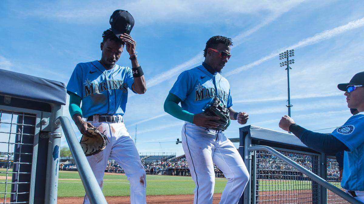Infielders Dee Gordon and Shed Long return to the dugout in a spring training game against the Padres on Thursday, March 5, 2020 at Peoria Stadium in Peoria, Ariz.