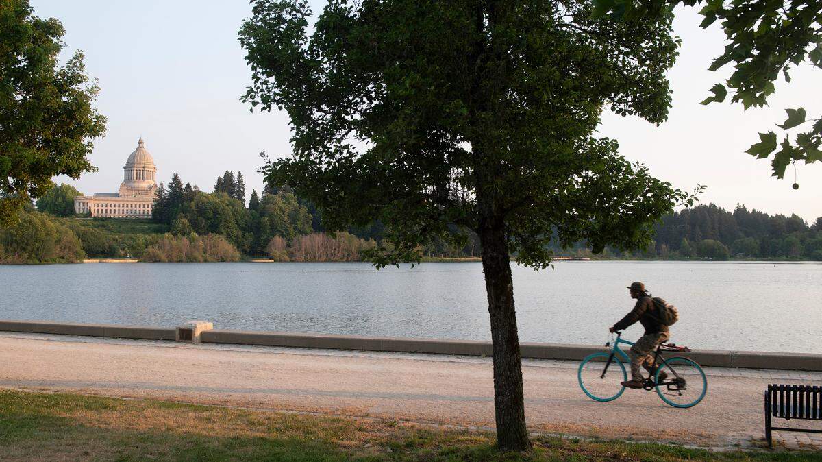 A man rides his bicycle through Heritage Park at Capitol Lake in Olympia.