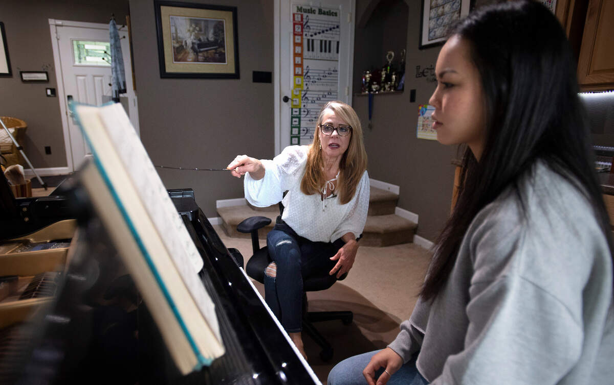 Kimberley Joe works with Bellarmine Prep senior Mia Filand, 17, in the piano studio at her home in Gig Harbor, Washington, on Friday, March 11, 2022. “My mother was a piano teacher and taught kids in the harbor. My dad owned Walt’s Piano Place and was a piano tuner,” she explained. “I was destined to become a piano teacher, because I was good at it.”