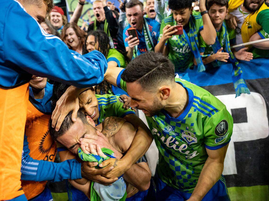 Seattle Sounders midfielder Nicolás Lodeiro, left, becomes emotional as he celebrates with teammates forward Raúl Ruidíaz, left, and midfielder Alex Roldan, right, during the second half of the second leg of the CONCACAF Champions League Final Pumas at Lumen Field in Seattle, on Wednesday, May 4, 2022. Lodeiro’s goal gave the Sounders a 3-0 lead which helped them to the Champions League title over Mexico’s Pumas.