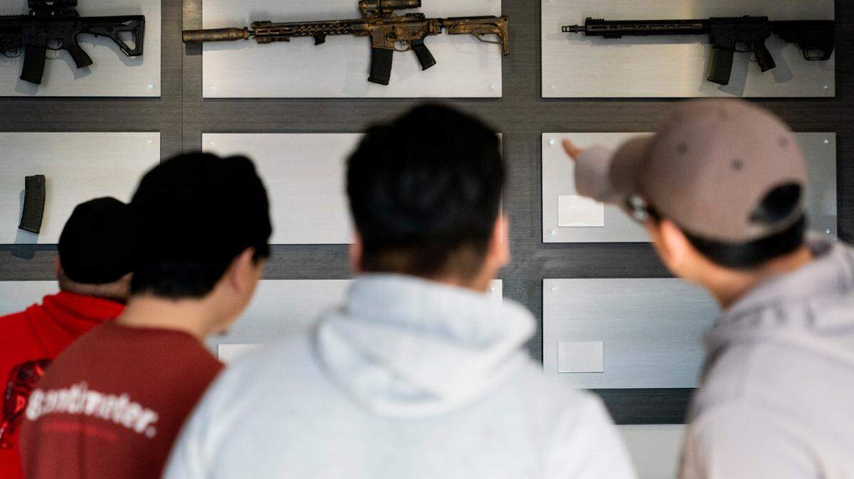 Customers look at AR-15-style rifles on a mostly empty display wall at Rainier Arms Friday, April 14, 2023, in Auburn, Wash. (AP Photo/Lindsey Wasson)