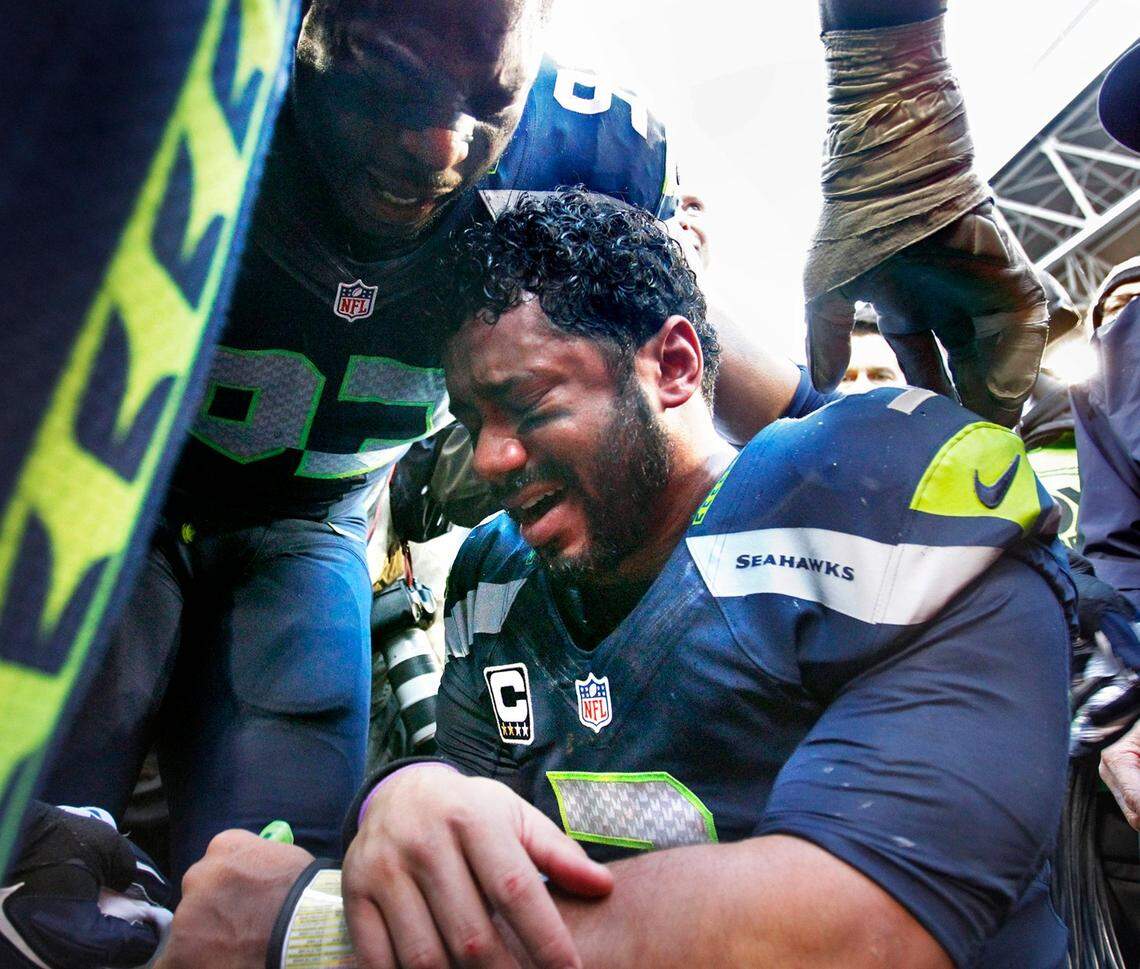 Seahawks quarterback Russell Wilson is comforted by teammate O’Brien Schofield following the Seahawks victory over the Green Bay Packers during the NFL Division Championship game at CenturyLink Field in Seattle on Sunday, Jan. 18, 2015.