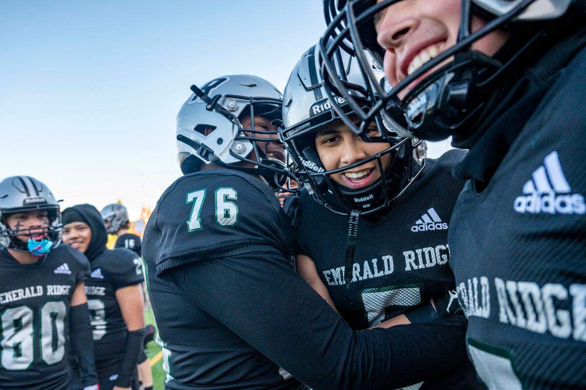 Emerald Ridge players celebrate on the sideline with receiver Tony Harste (center-right) after he caught a touchdown pass from quarterback Jake Schakel during the first quarter of a Week 10 4A playoff game against Bothell on Saturday, Nov. 5, 2022, at Sparks Stadium in Puyallup, Wash.