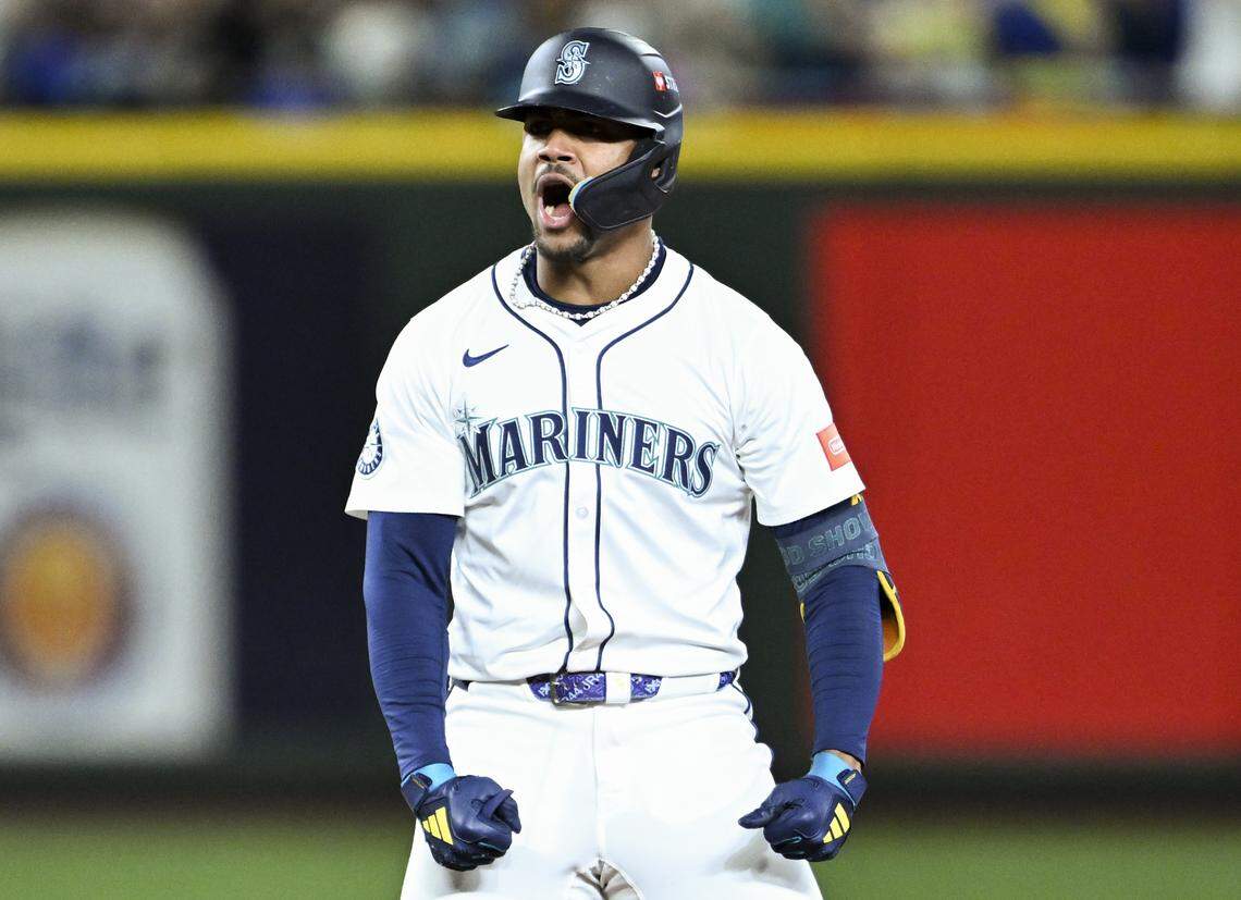 Seattle Mariners center fielder Julio Rodríguez (44) reacts to a double, and Seattle Mariners third baseman Eugenio Suárez (28) scoring a run during the eighth inning of Game 2 of the AL Division Series against the Detroit Tigers at T-Mobile Park, on Sunday, Oct. 5, 2025, in Seattle.