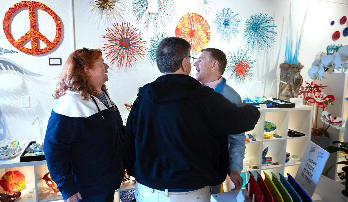 Business manager Charles Jorgenson (right) greets visitors Barb and Jim Cieslak of Federal Way to the Marcus Harper GlassWorks gallery in the burgeoning glass-art scene of the Proctor District in Tacoma, on Tuesday, June 11, 2024.