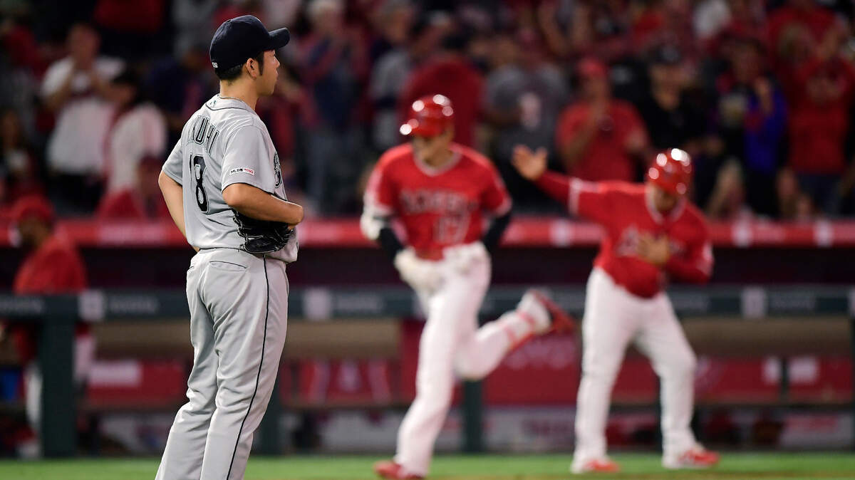Seattle Mariners starting pitcher Yusei Kikuchi, left, waits as Los Angeles Angels’ Shohei Ohtani, center, is congratulated by third base coach Mike Gallego as he rounds third after hitting a solo home run during the fourth inning of a baseball game Saturday, June 8, 2019, in Anaheim, Calif.