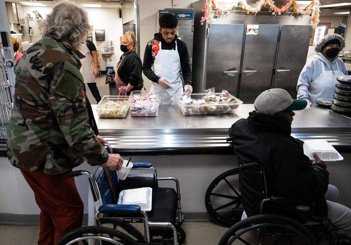 Volunteers serve warm meals to unhoused people at the Tacoma Rescue Mission on Thursday, April 14, 2022.