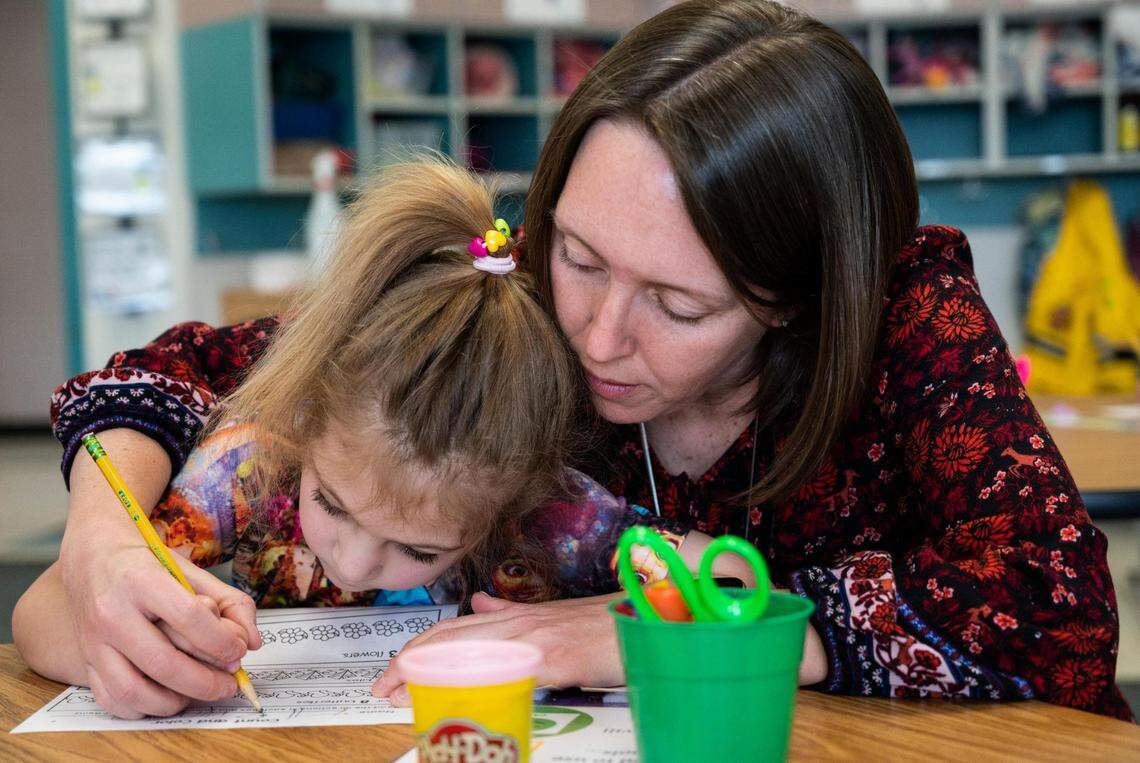 Michelle Cook, right, helps her transitional kindergarten student, Evelyn Paulson, left, count and color during a class activity at Harbor Heights Elementary School on Thursday, April 28, 2022 in Wollochet, Wash. Cook teaches a new six-month transitional kindergarten program to get kids prepared for kindergarten that was started this year by the Peninsula School District.