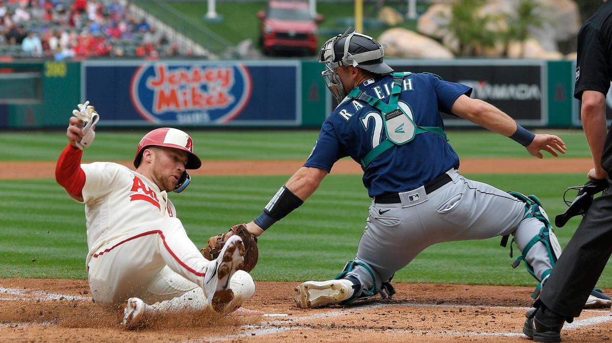 Los Angeles Angels’ Brandon Drury, left, scores on a single by Matt Thaiss as Seattle Mariners catcher Cal Raleigh makes a late tag during the first inning of a baseball game Sunday, June 11, 2023, in Anaheim, Calif. (AP Photo/Mark J. Terrill)